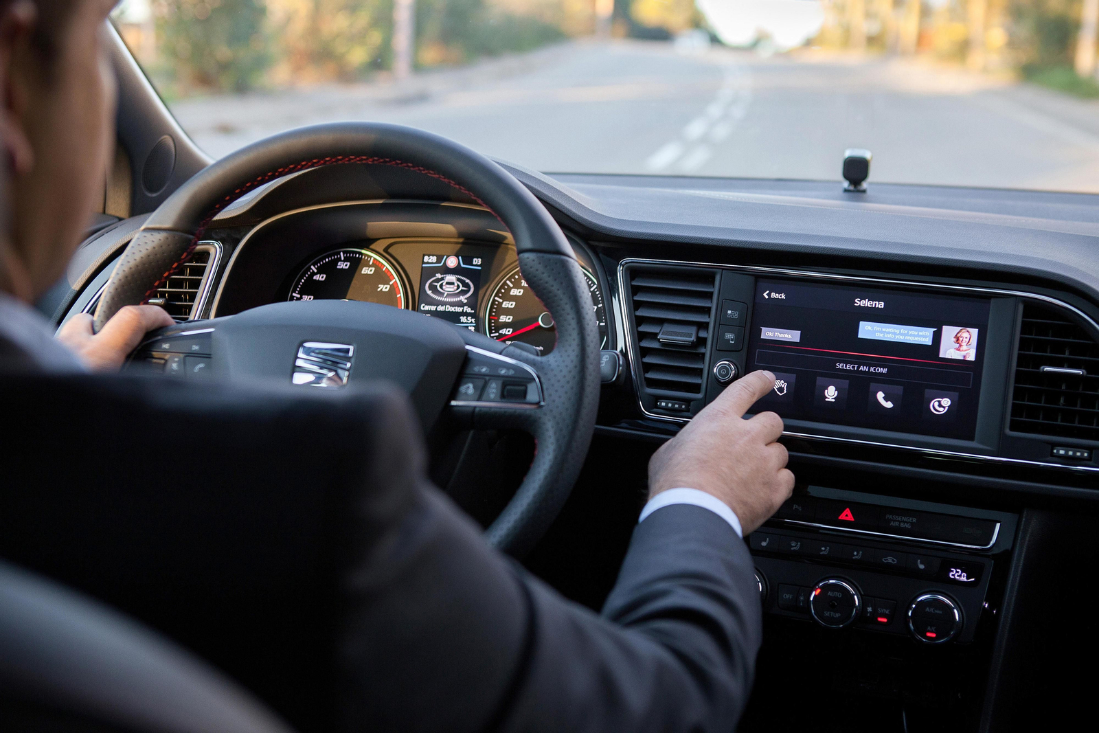 Una persona al volante trata de cambiar la música.