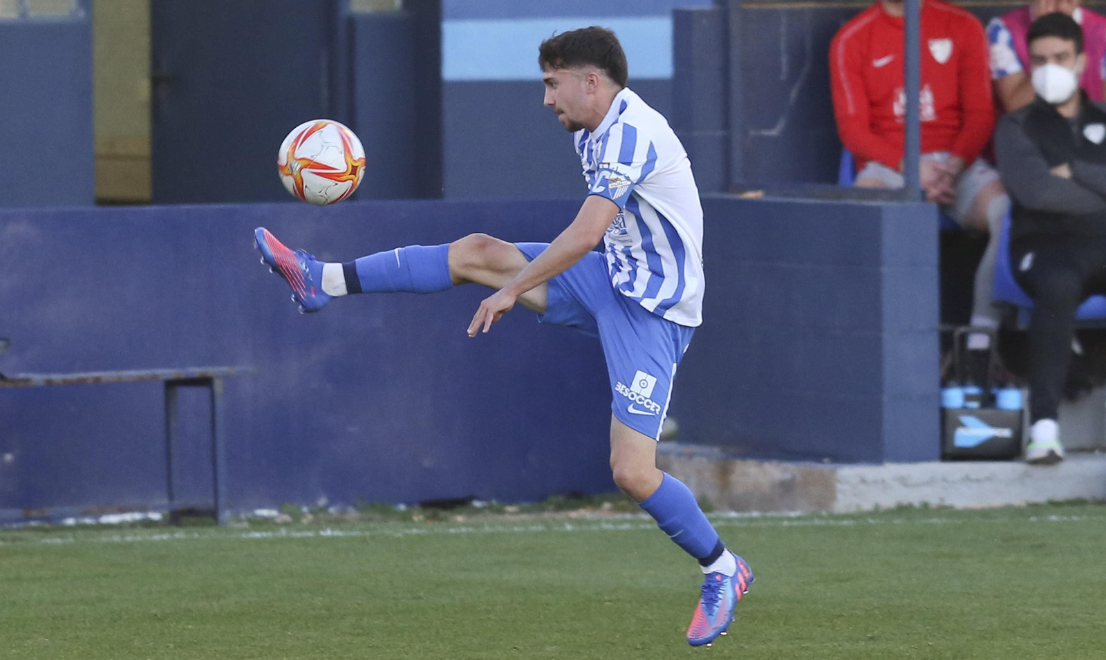 Ale Benítez, con el brazalete del Malagueño, controla un balón.