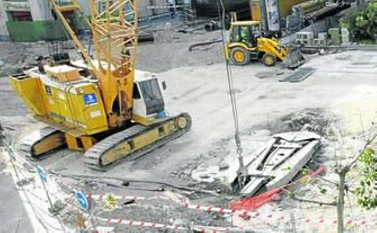 Maquinaria pesada se afanaba ayer por construir el gran pozo para recoger las aguas pluviales en la plaza de San Juan de Dios.