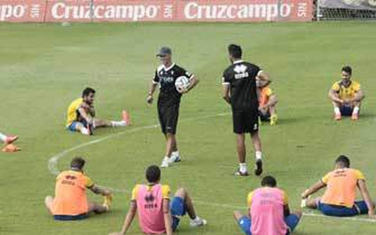 Calderón, en el centro con un balón mientras los jugadores hacen estiramientos. /Fito Carreto