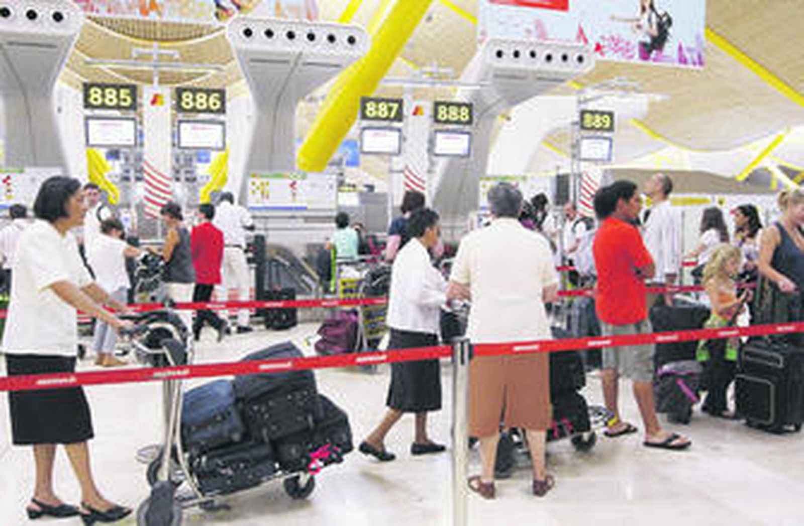 Usuarios hacen cola para facturar su equipaje en una terminal del aeropuerto de Barajas.