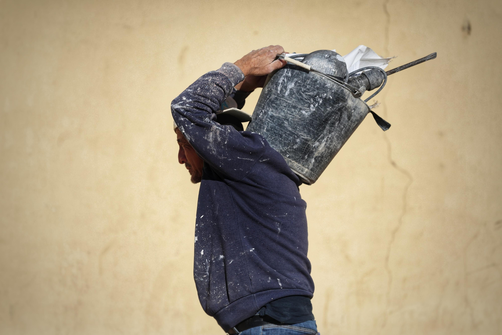 Un obrero carga con sus materiales en Málaga.