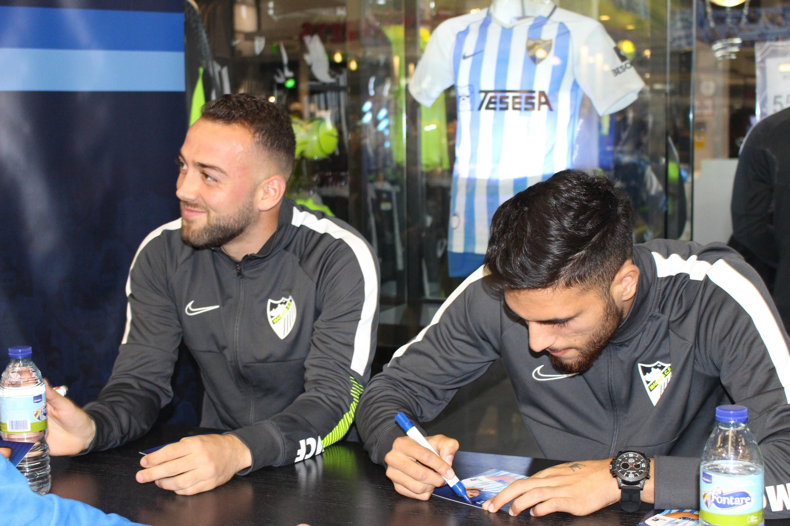 Antoñín y Keidi Bare se hacen fotos y firman a los aficionados del Málaga CF