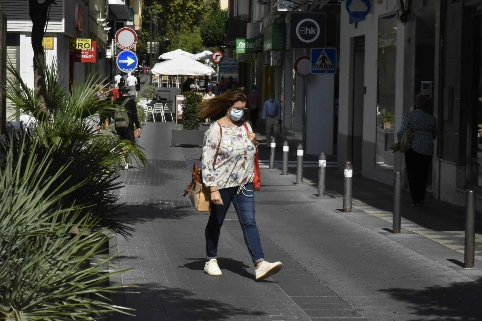 Una mujer camina con mascarilla por la calle Convento de Algeciras.
