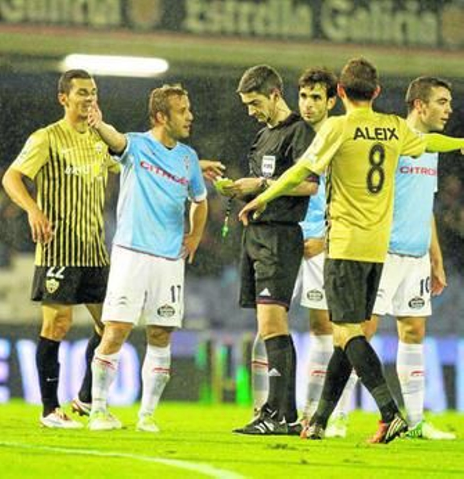 Joan Tomás protesta a Undiano Mallenco en el Celta-Almería de Copa rodeado de sus compañeros Oubiña y Aspas, y los visitantes Casquero y Aleix Vidal.