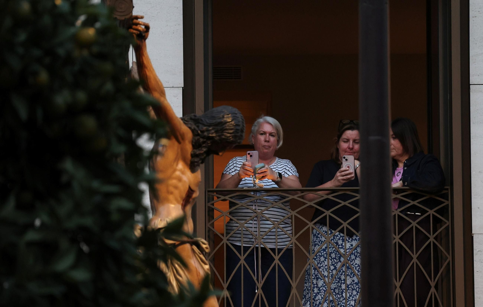 Unas turistas hacen fotos al Cristo de la Buena Muerte desde un hotel de la Magdalena.