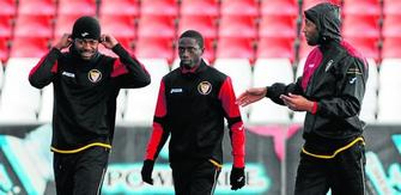 Kanoute bromea con Romaric durante el entrenamiento realizado por el Sevilla en presencia de Dabo.