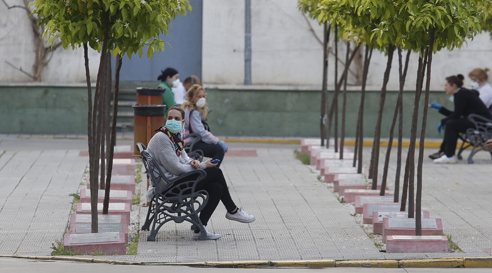 Varias personas esperan en el Jardín de los Trasplantes, a las puertas de Urgencias del Reina Sofía.