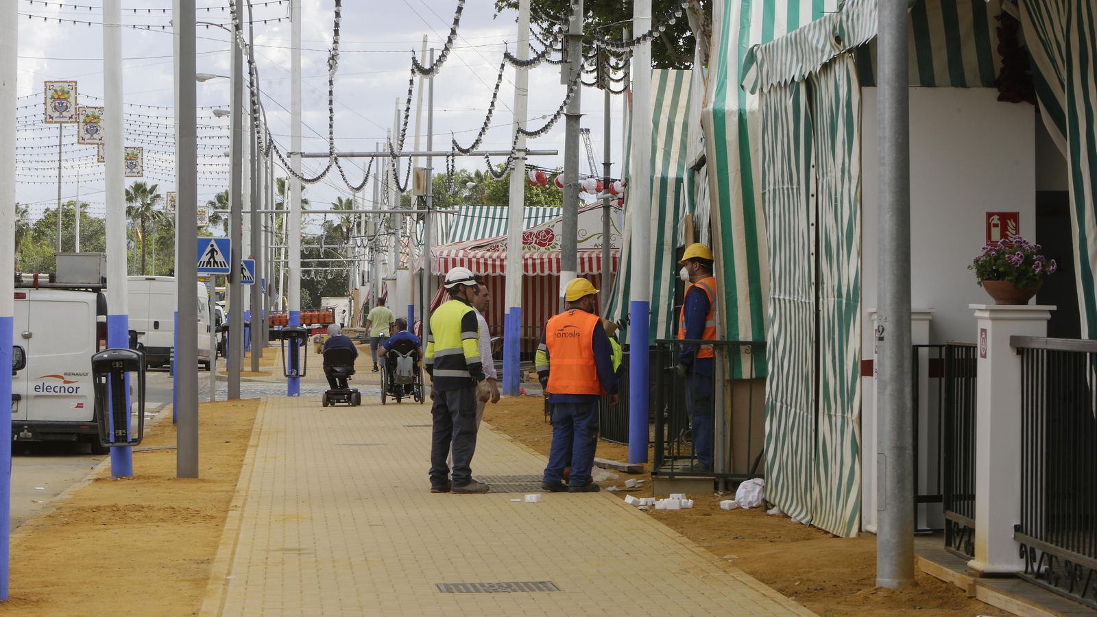 Varios operarios a las puertas de una caseta con y sin mascarilla.