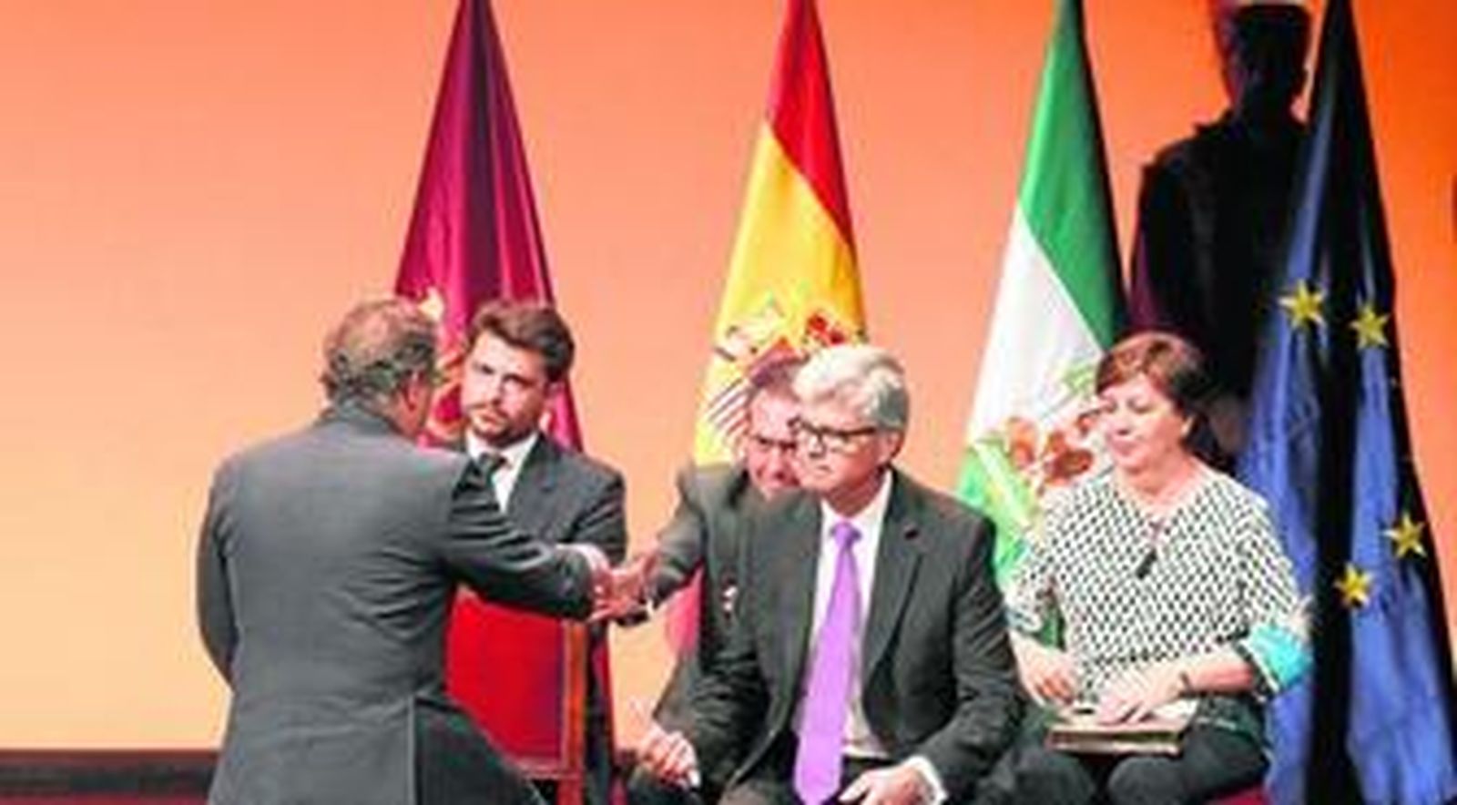 Zoido estrecha su mano a Espadas tras concluir su discurso en la entrega de las medallas del día de Sevilla.