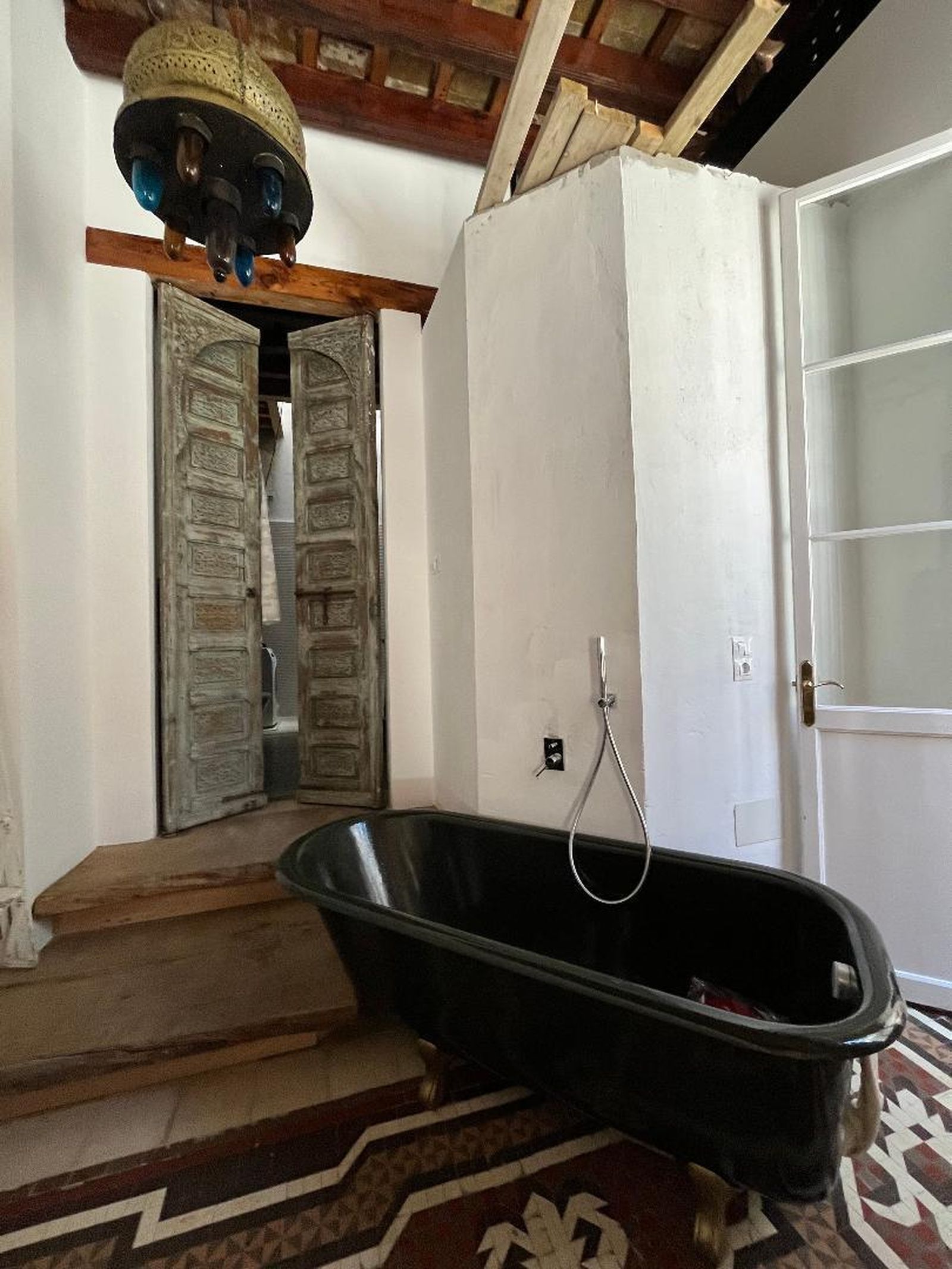 Esta bañera se ubica en el dormitorio principal, junto a unas puertas marroquíes que dan acceso al baño.