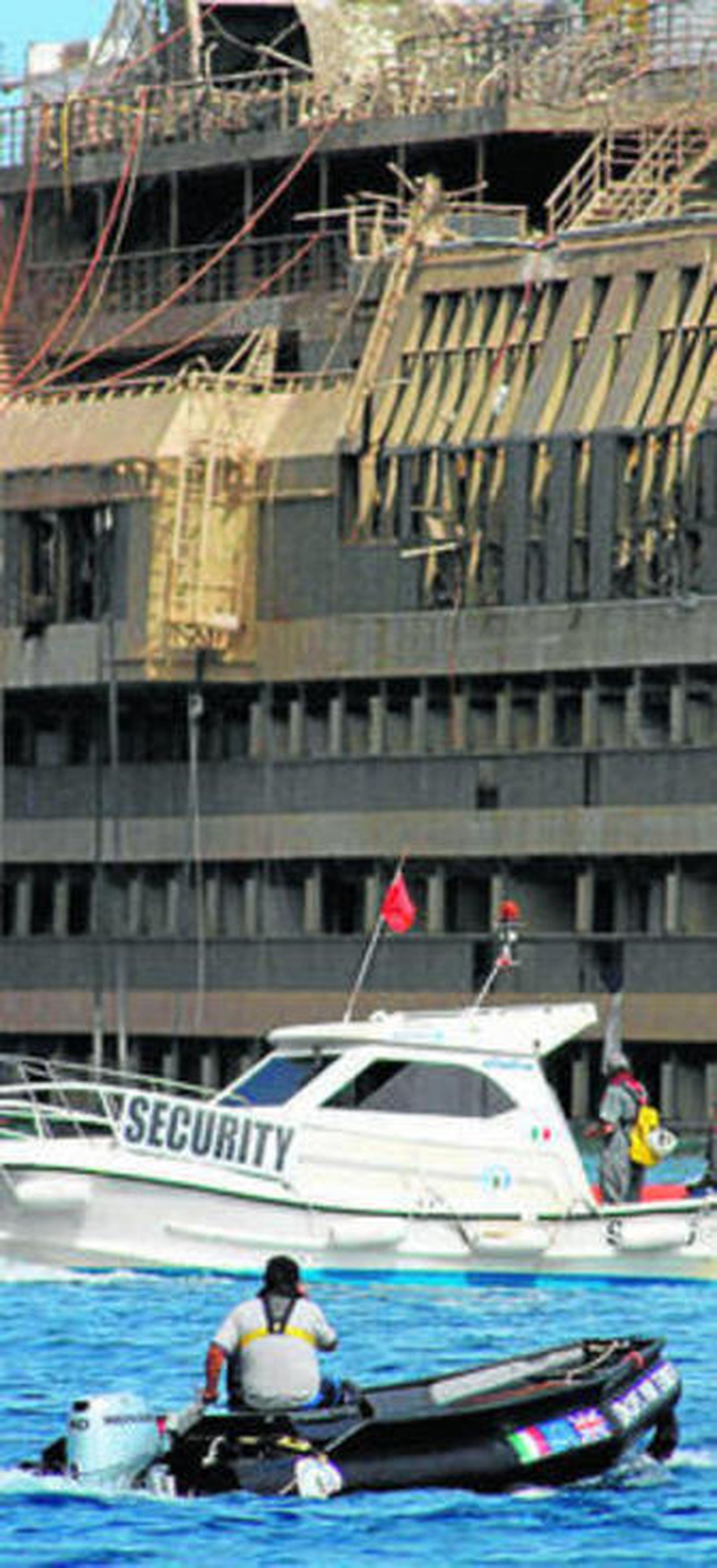 Una embarcación auxiliar pasa junto al crucero 'Costa Concordia'.