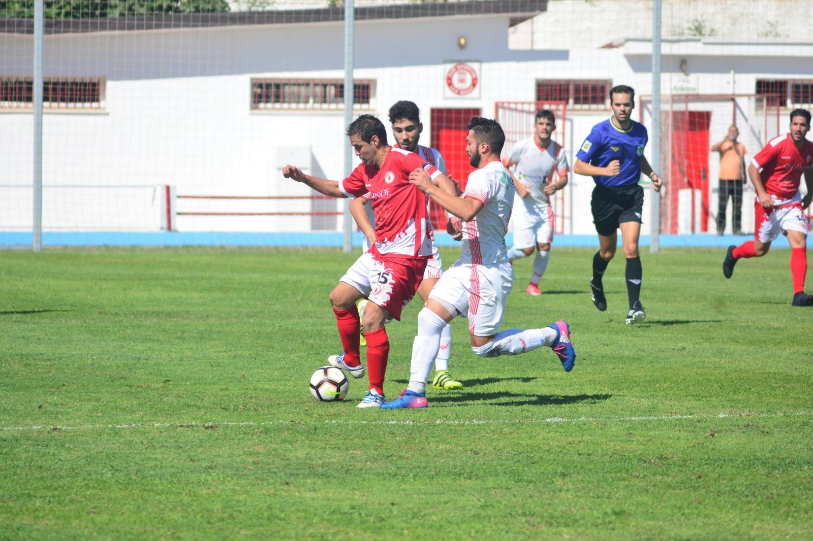 Alexis de la Paz, que fue expulsado, trata de aguantar el balón ante la entrada de dos jugadores de La Palma.