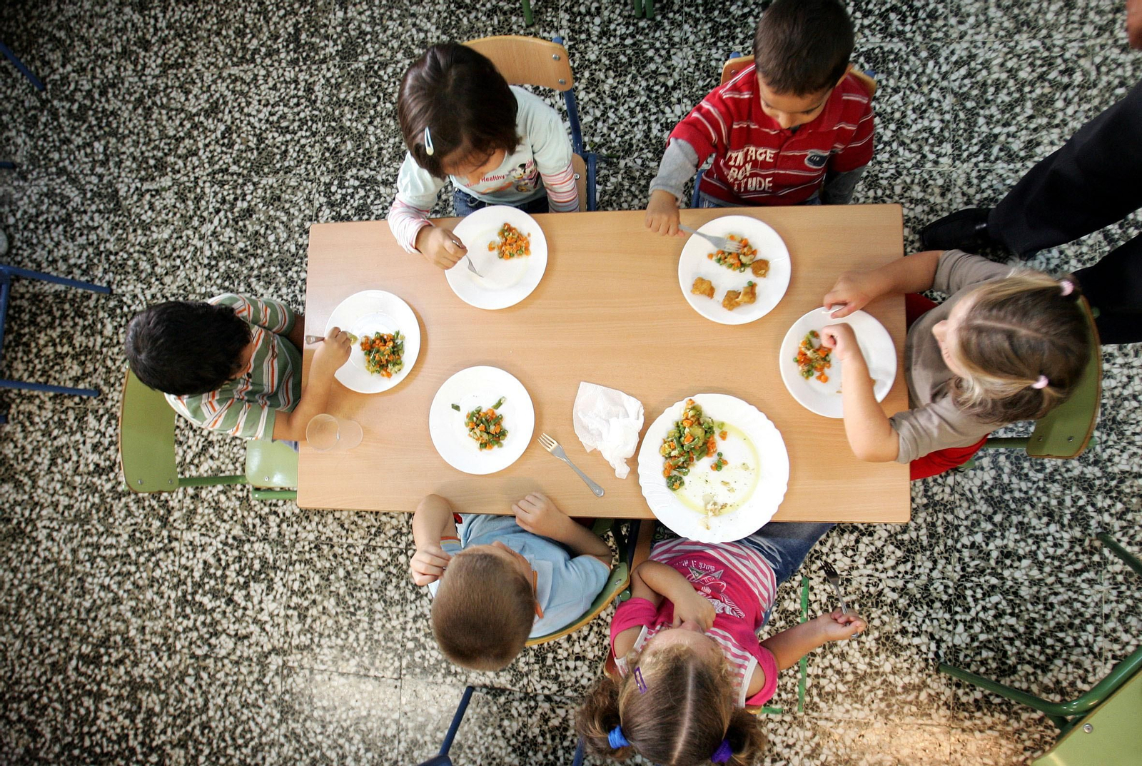 Un grupo de niños almuerza en el colegio.