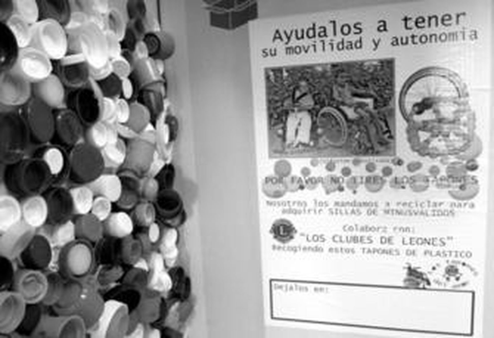 Una caja para la recogida de los tapones y un montos de estos plásticos de distinto origen.