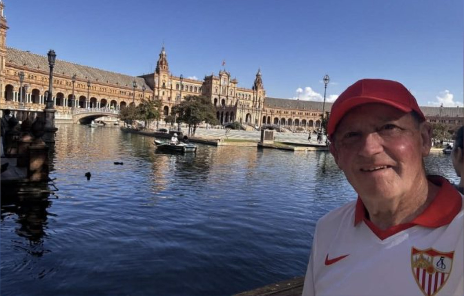 Alan Gormley posa con un polo del Sevilla con la Plaza de España de fondo.
