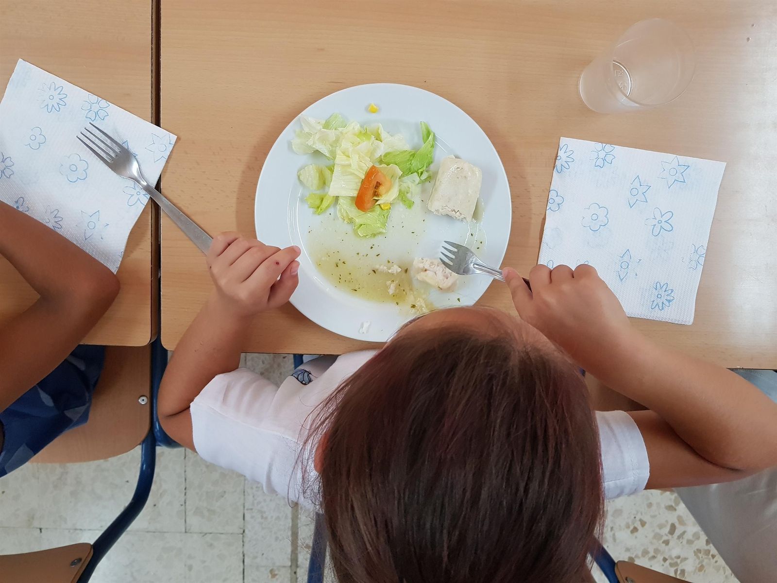 Una niña en un comedor escolar.