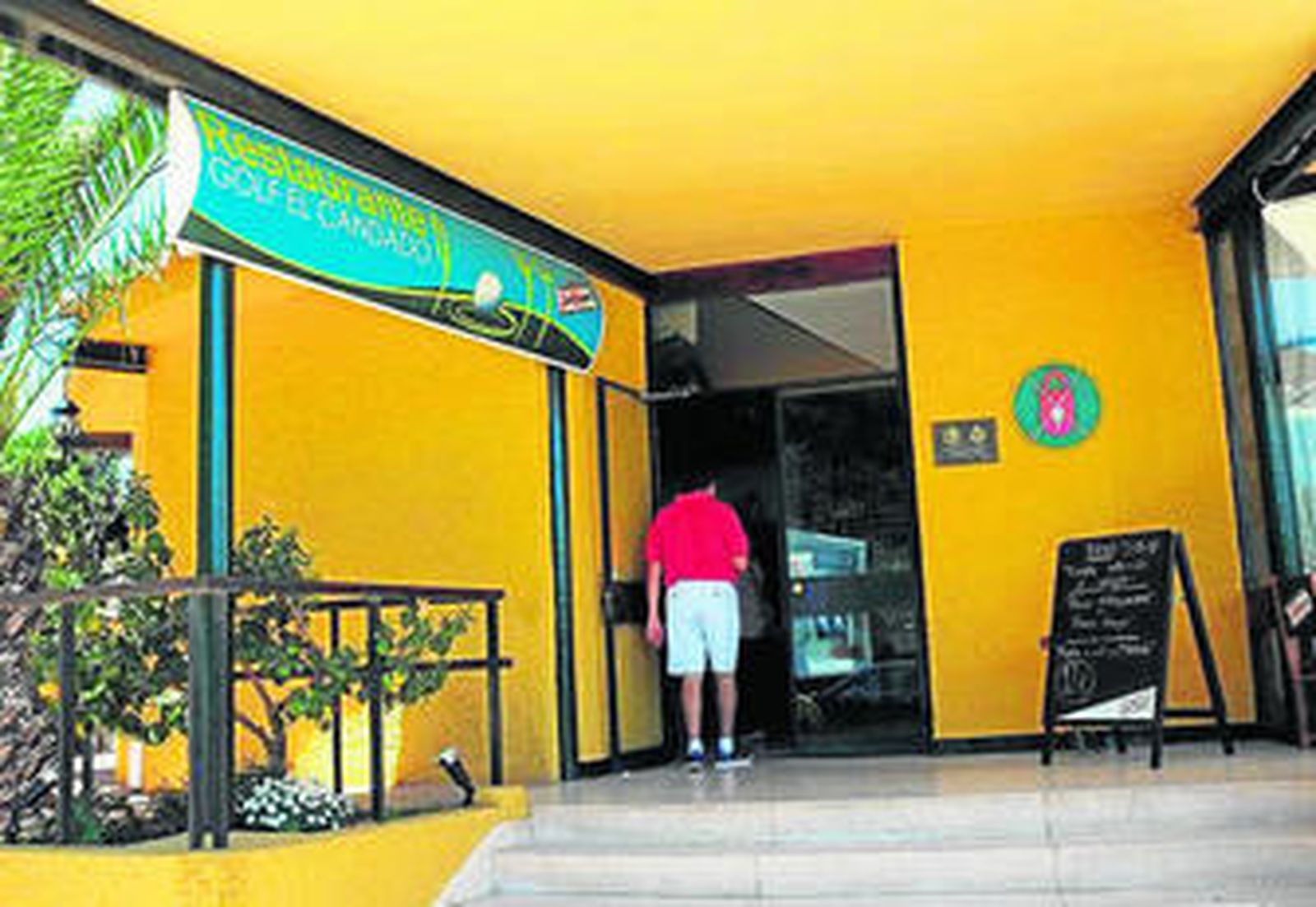 1. Entrada a la parte del bar. 2. Vistas al campo de golf desde el salón del restaurante. 3. El salón del El Candado Golf con gran capacidad para comensales. 4. Terraza del restaurante. Al fondo, la zona de aparcamiento y la parte que están adecuando para ocio nocturno. 5. El chef Javier Hernández muestra una de sus paellas.