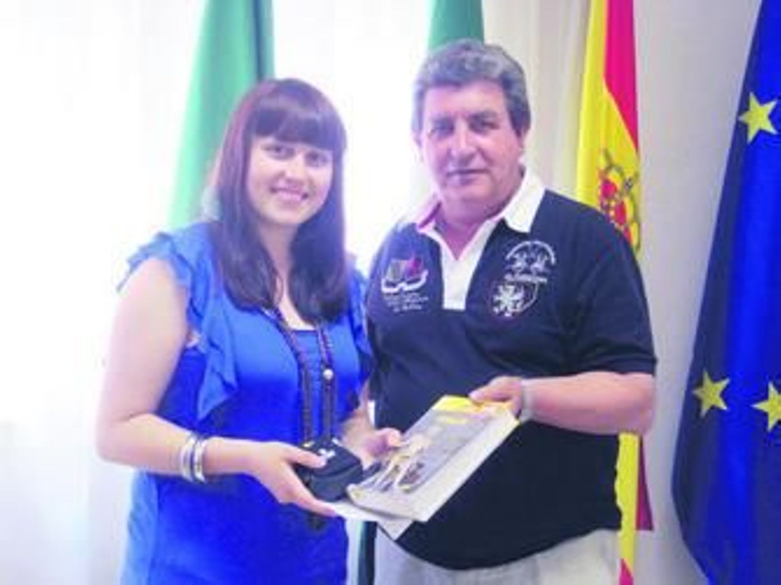 El diputado de Fomento, Joaquín Álvarez, entrega una guía de Italia a la joven voluntaria.