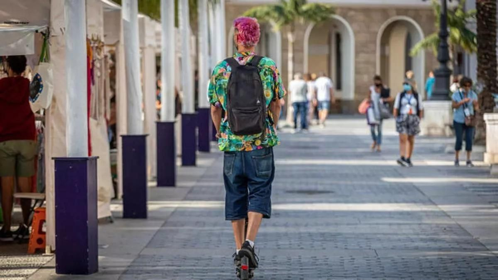 Un conductor de patinete eléctrico, por el centro de Cádiz en una vía peatonal