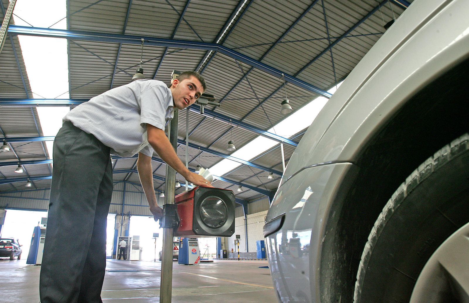 Un operario revisa los faros de un turismo en una estación ITV.