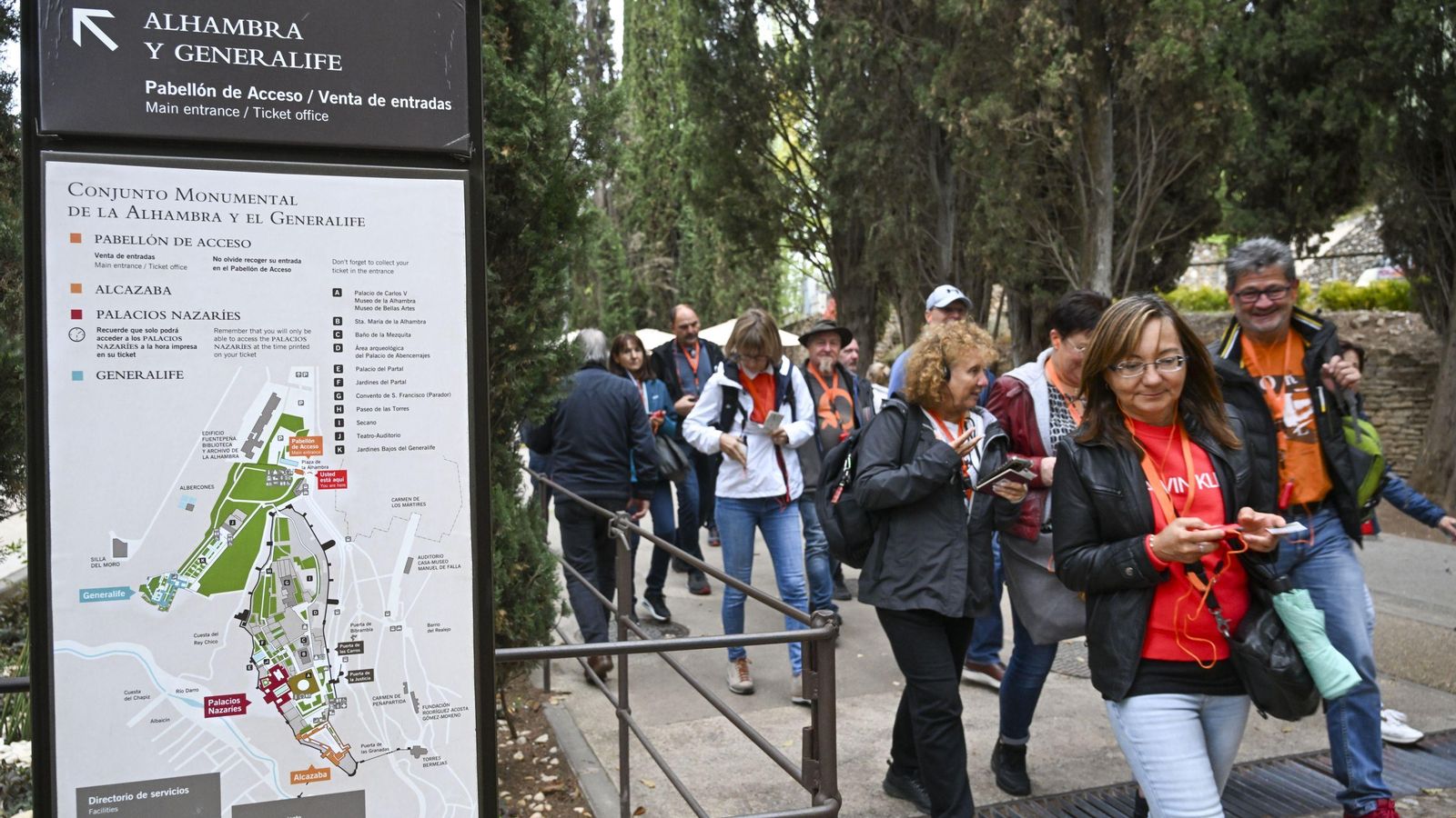 Un grupo de turistas accede a la Alhambra acompañados de una guía