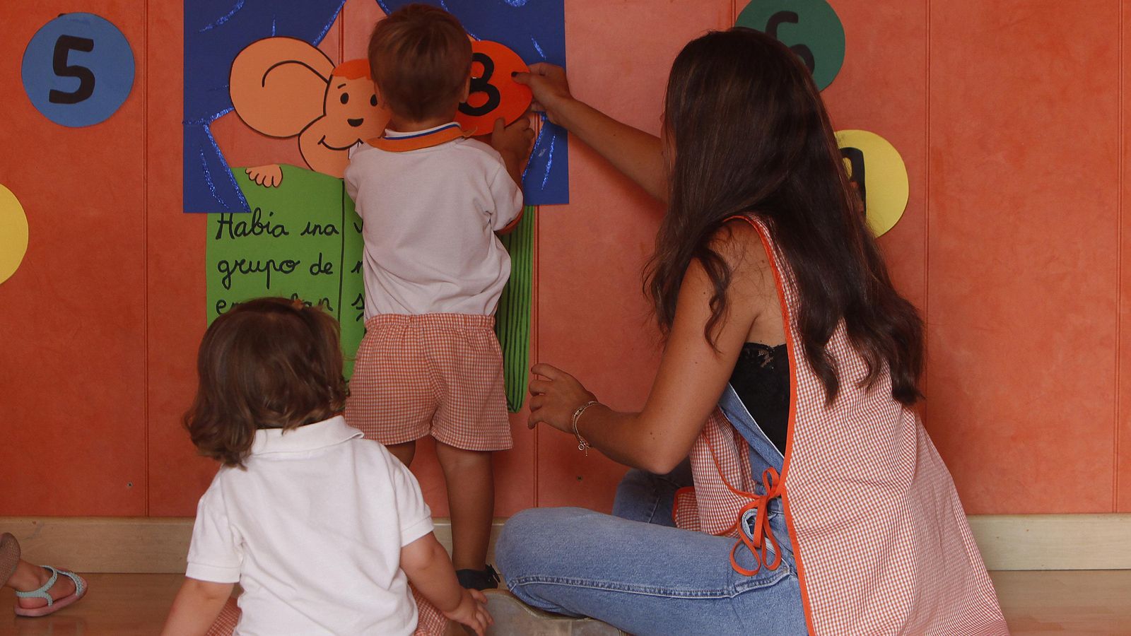 Un menor realiza una actividad junto a su profesora en una guardería.