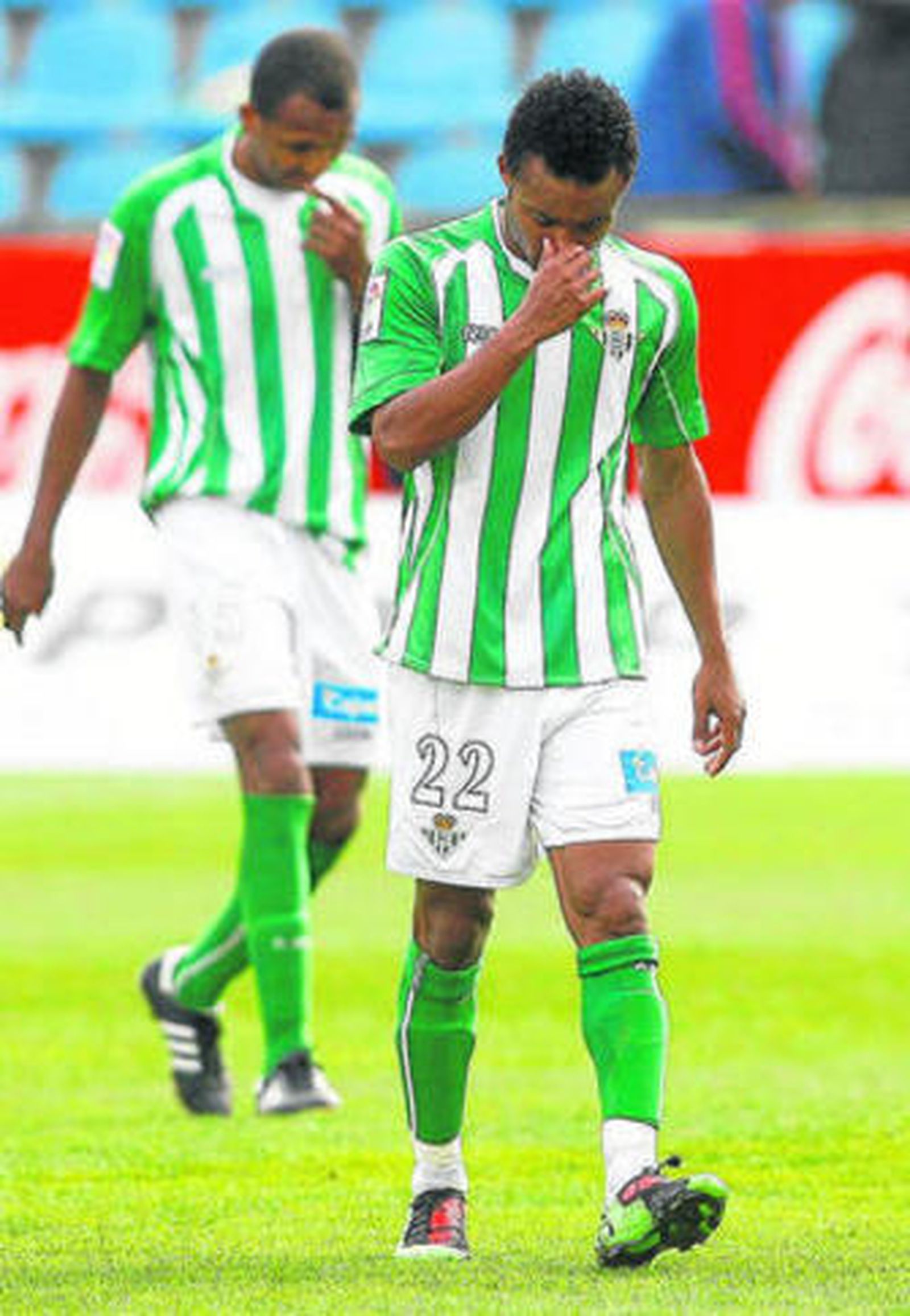 Nelson, seguido por Mehmet Aurelio, se retira cabizbajo del campo.