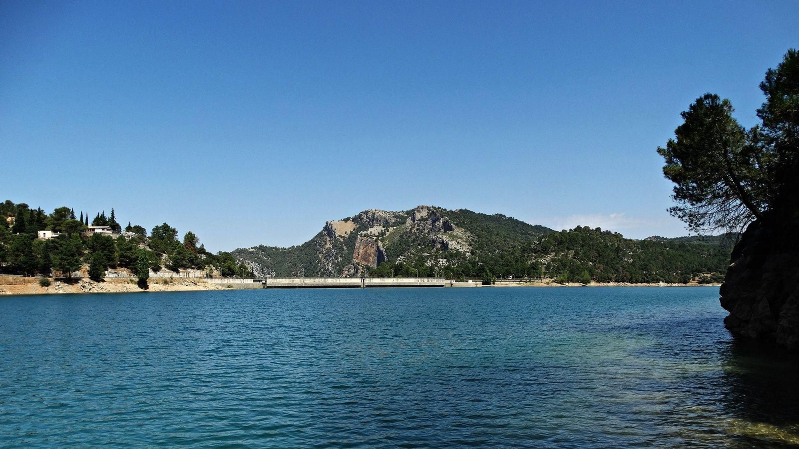 Pantano de Aguascebas con viviendas en el margen izquierdo.