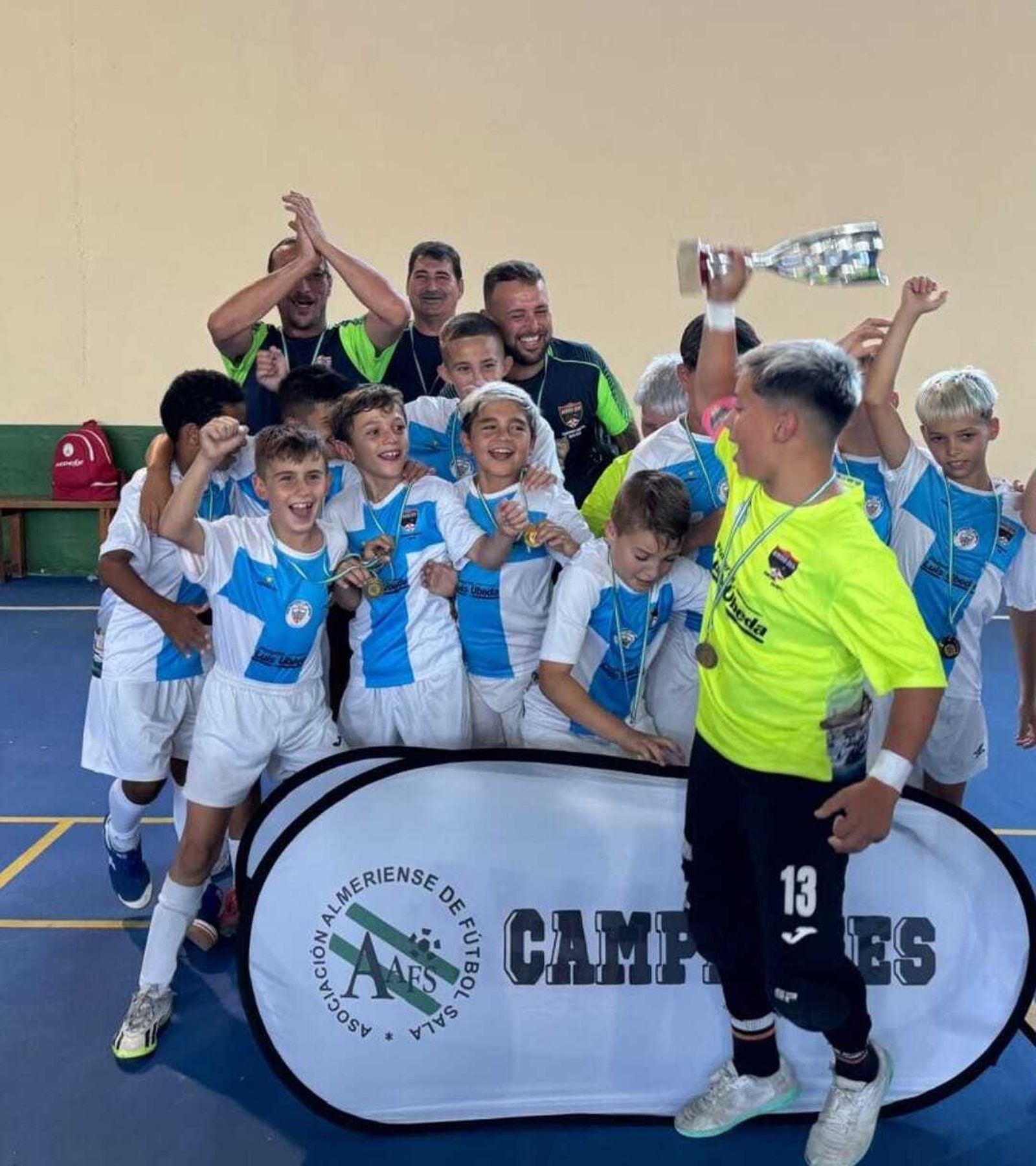 Los jugadores de la Peña Regiones reciben el título tras proclamarse campeones en categoría alevín.