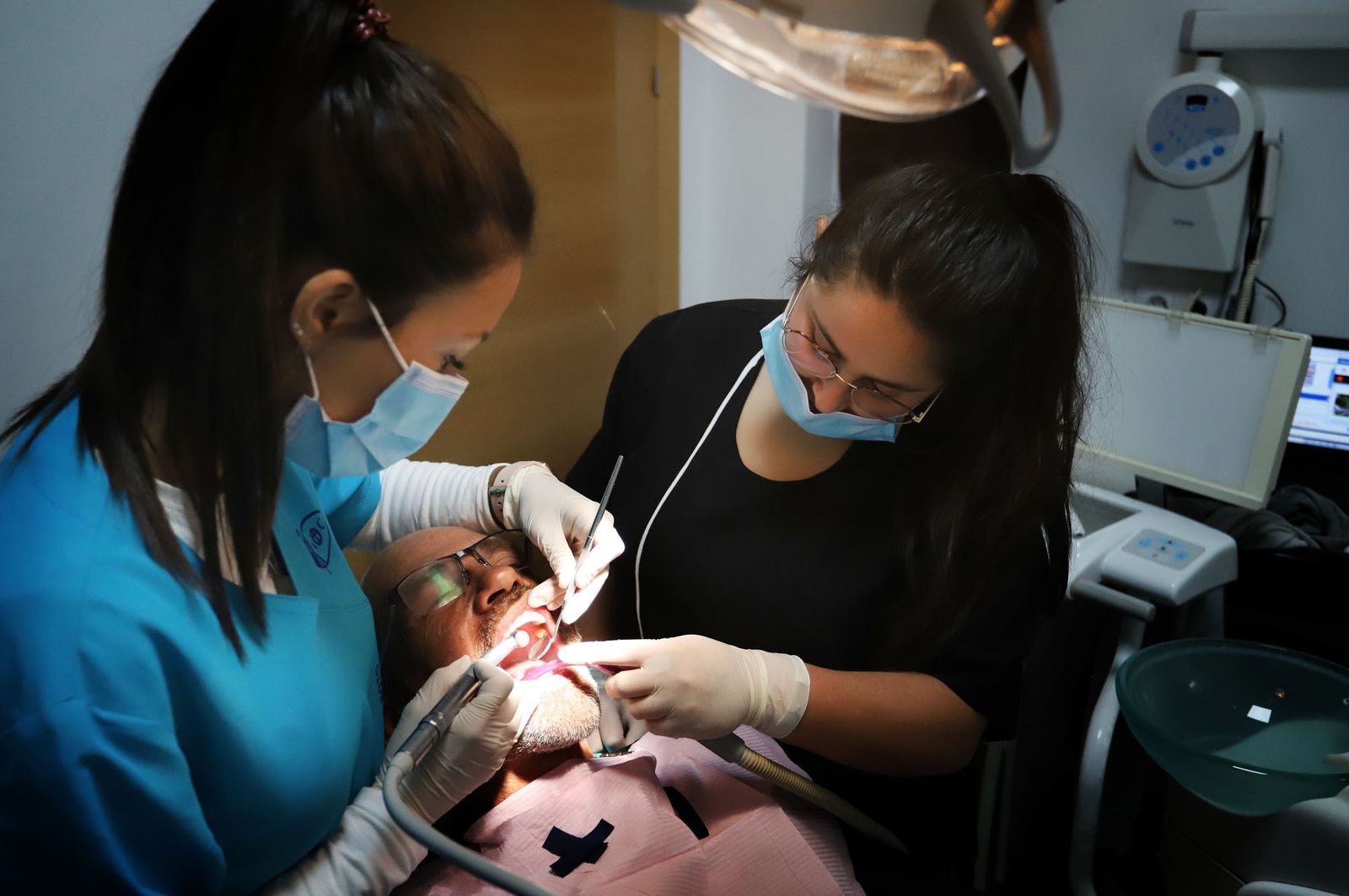 Dos dentistas atienden a una persona.