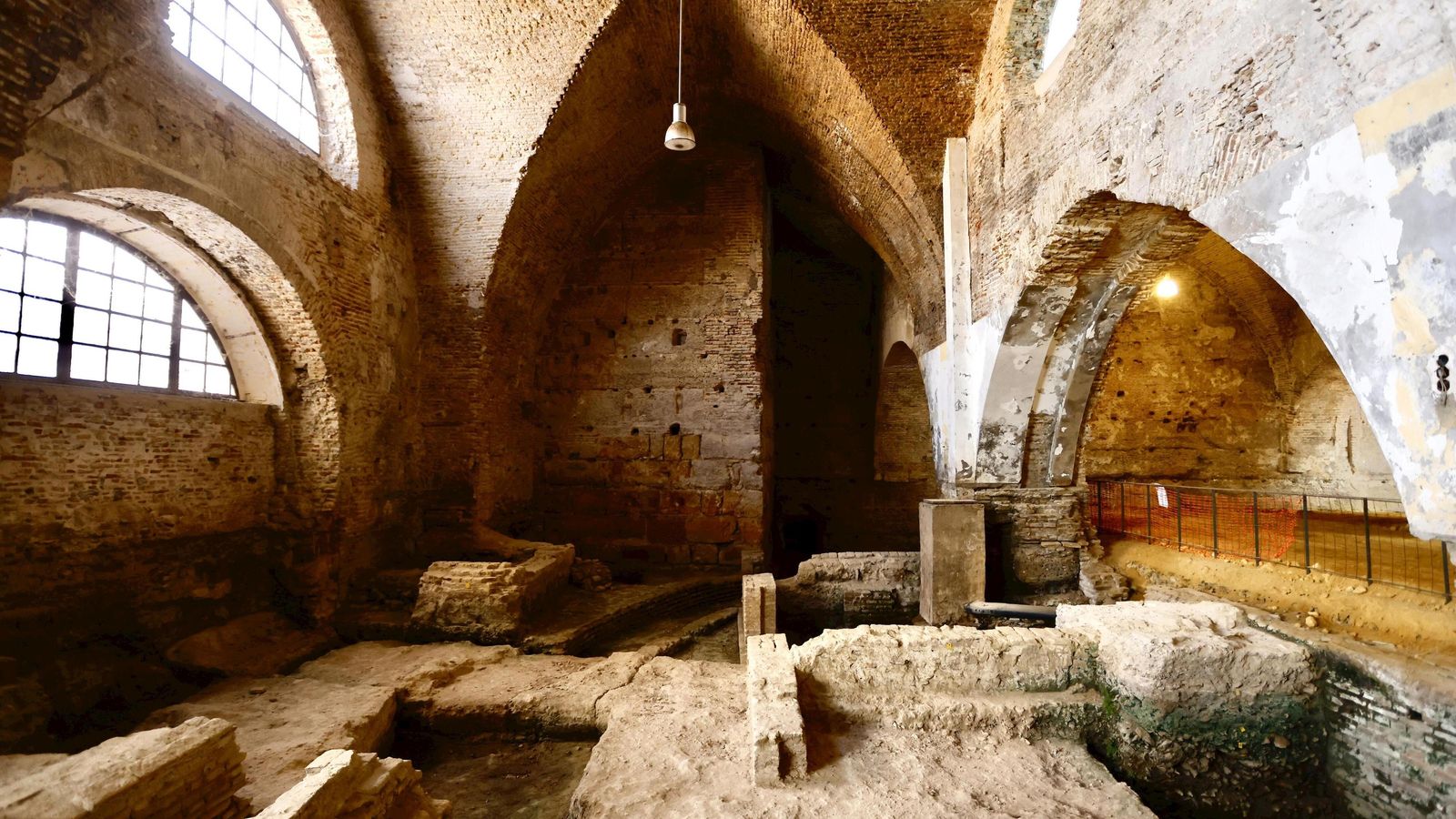 Restos de las antiguas pescaderías en primer término. Al fondo, se observa una de las torres que formaba la puerta del Postigo del Aceite.