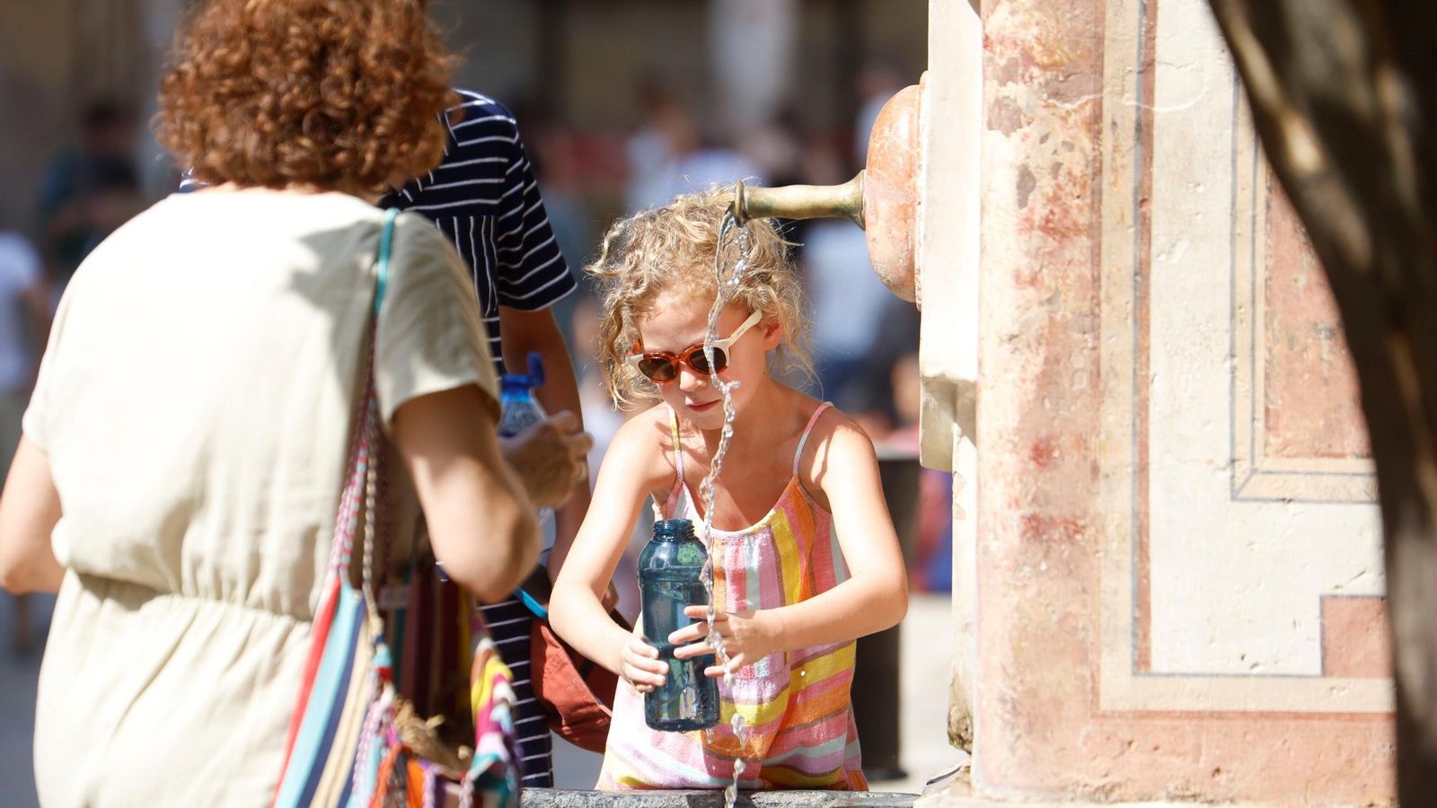 Turistas refrescándose en una de las fuentes del Patio de los Naranjos