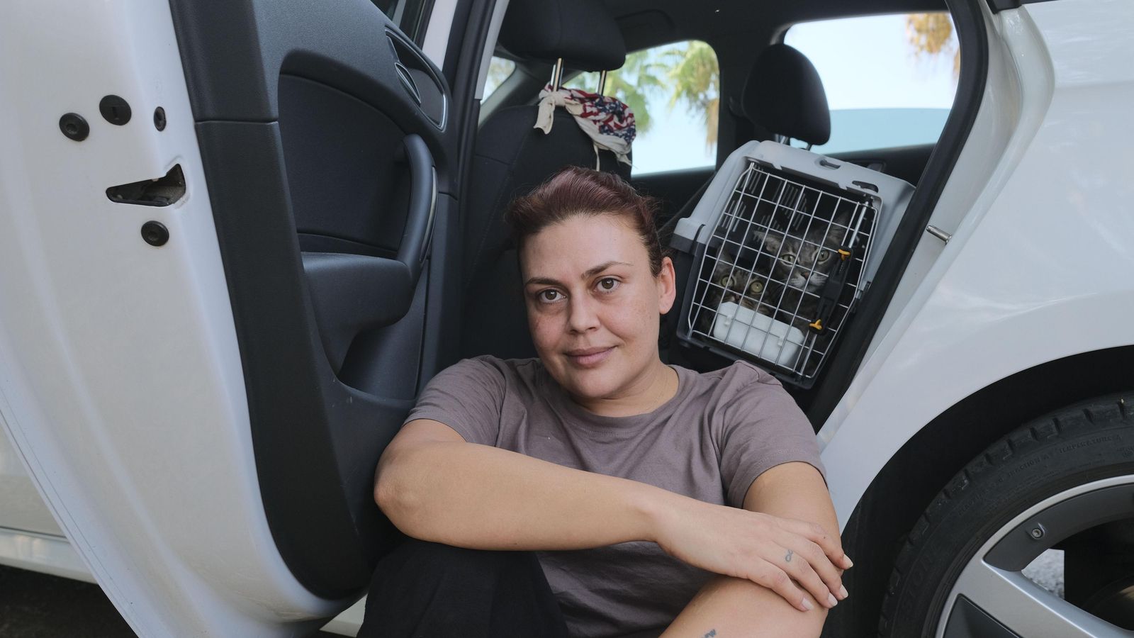 Vecina desalojada en su coche con sus gatos.