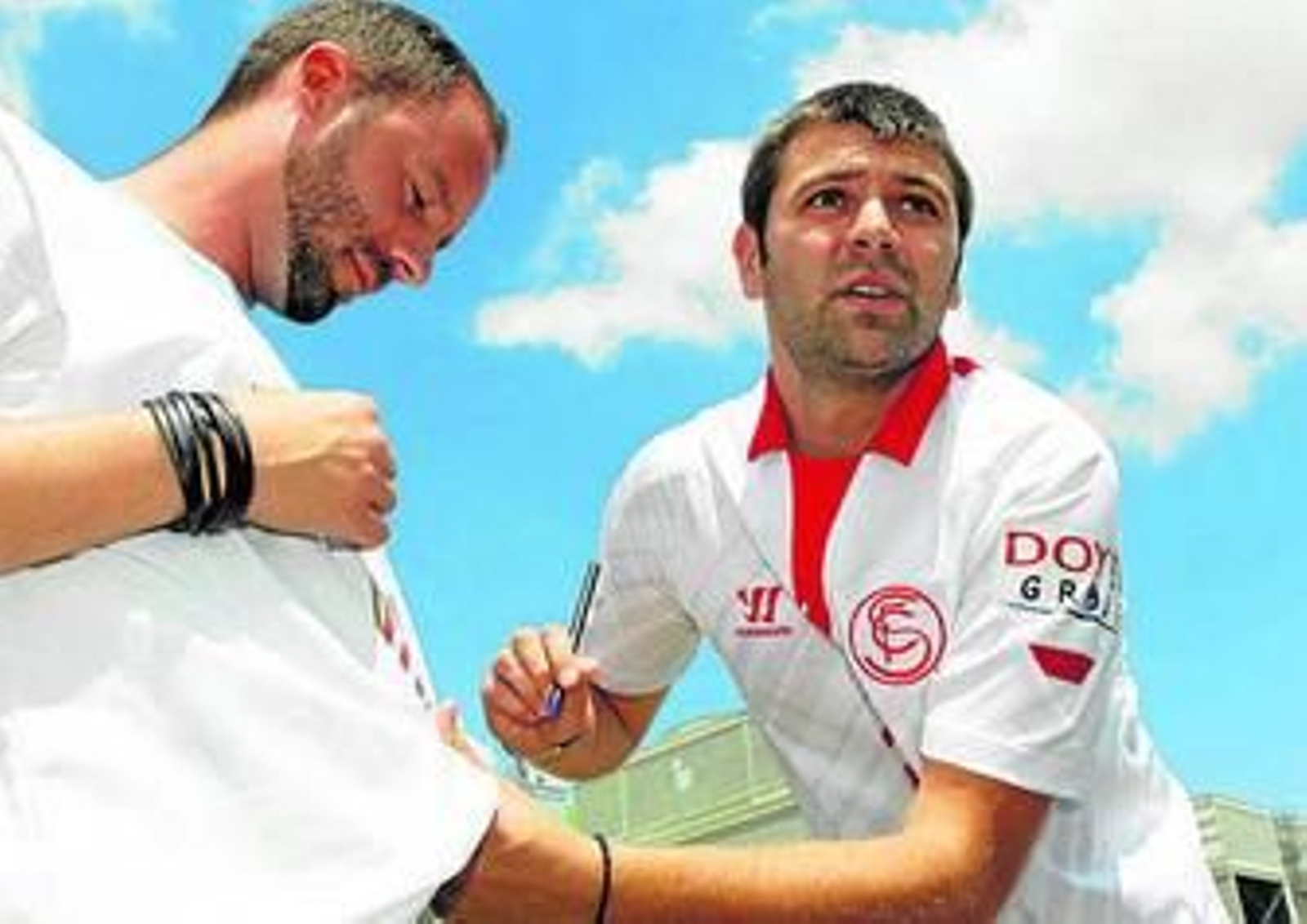 Rusescu, con su nueva camiseta, firma un autógrafo a un aficionado.