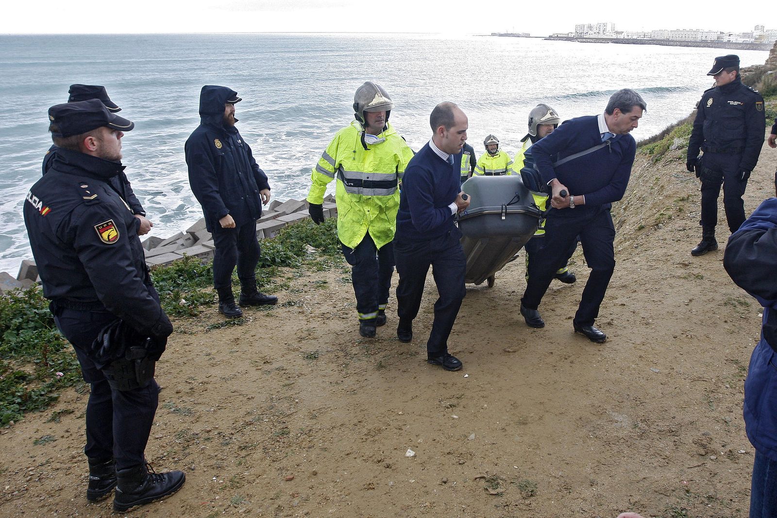 Operarios de la funeraria se llevan el cadáver.