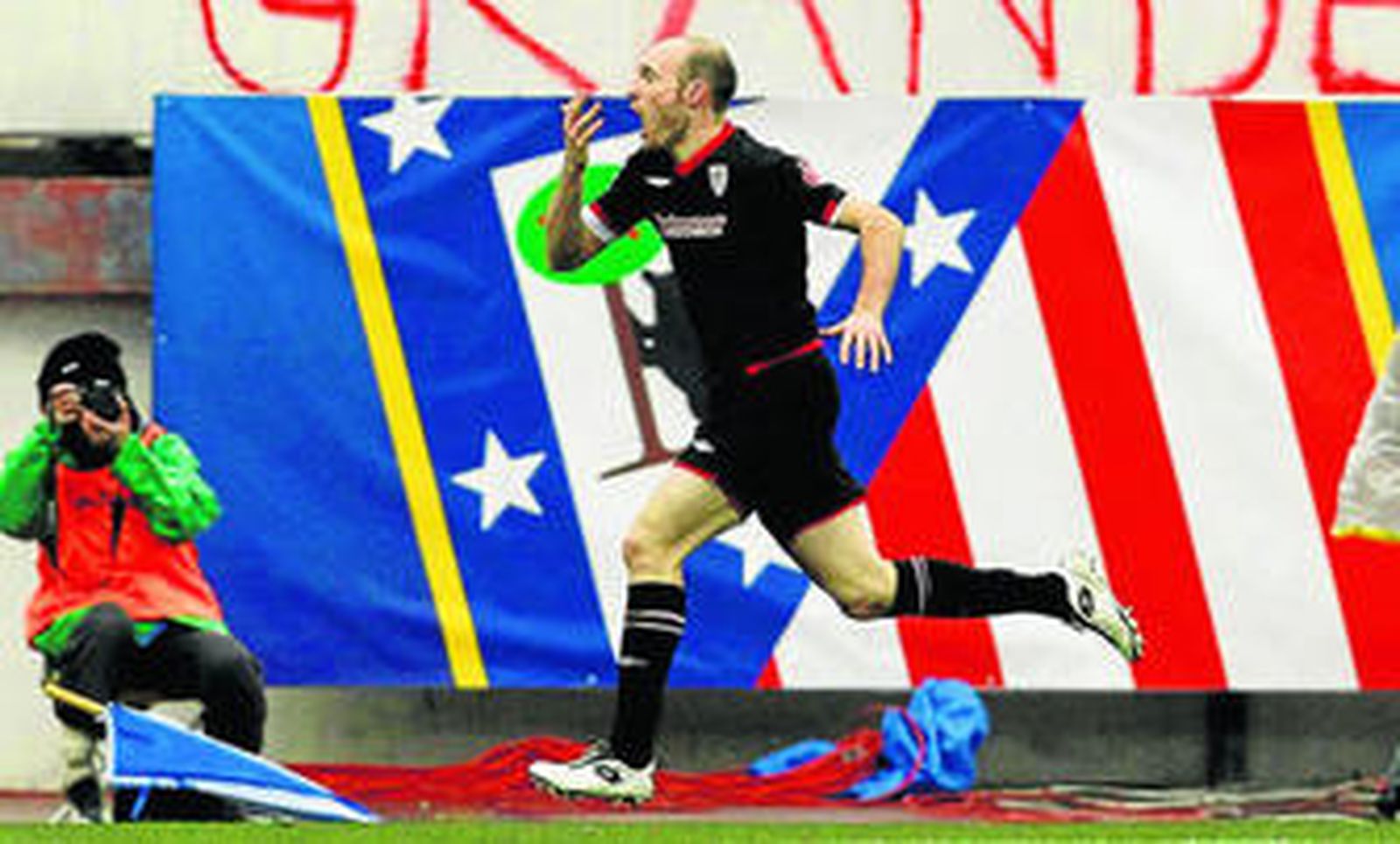 Toquero celebra uno de sus dos goles en el Calderón pasando ante un gran escudo del Atlético.
