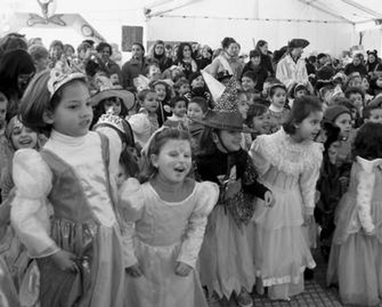 Todos los escolares que acudieron a la fiesta de carnaval en la carpa de la plaza de La Merced iban disfrazados. A la derecha la murga de El Grupito.