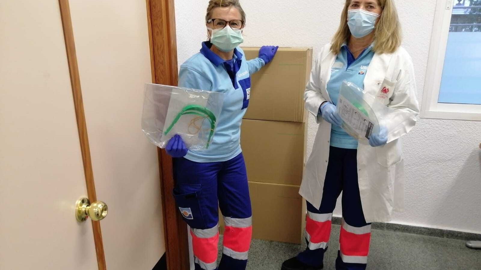 Dos sanitarias muestras las pantallas protectoras donadas.