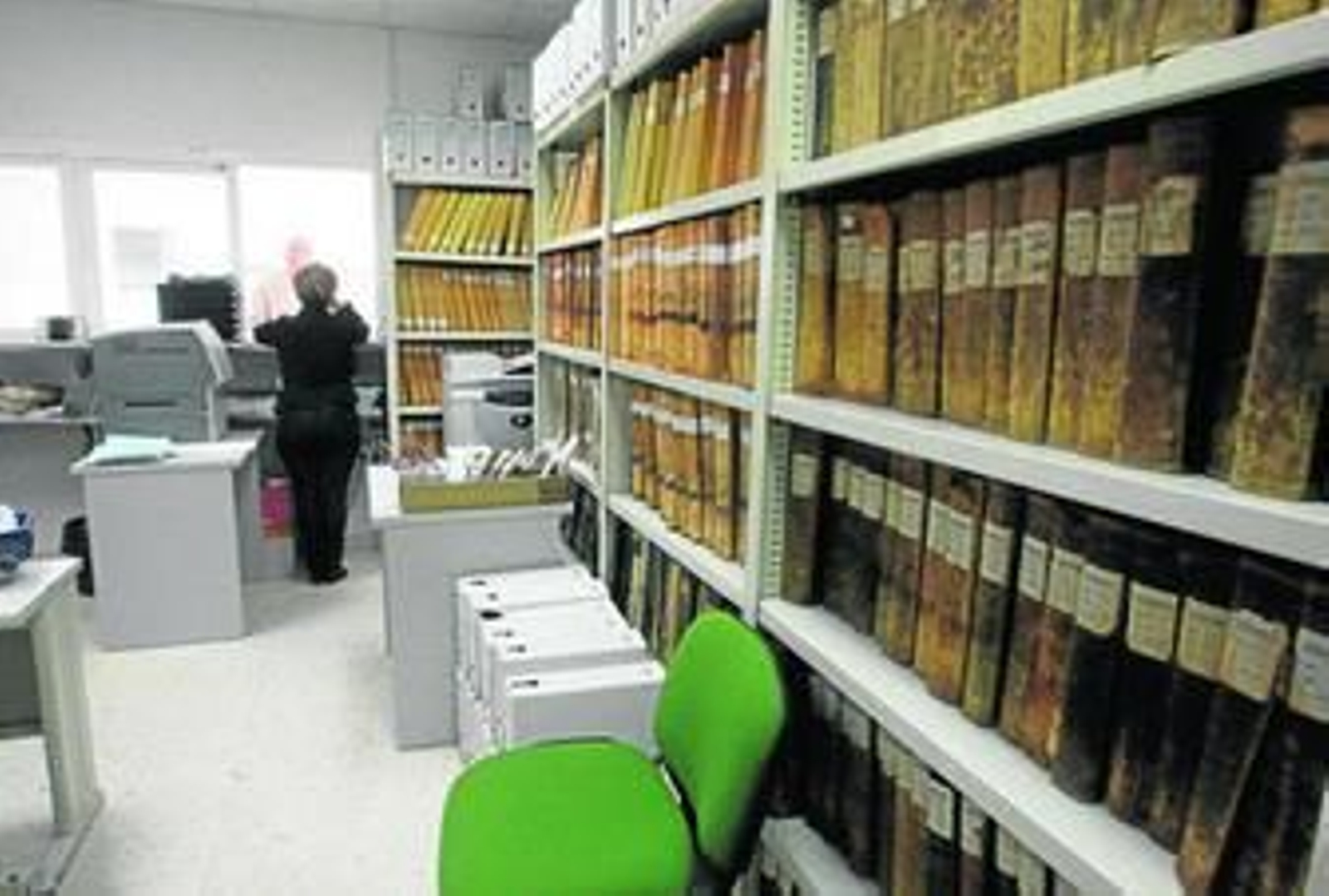 Instantánea de la oficina del Registro Civil, en la que se ve a una de las empleadas atendiendo a un hombre por la ventanilla.