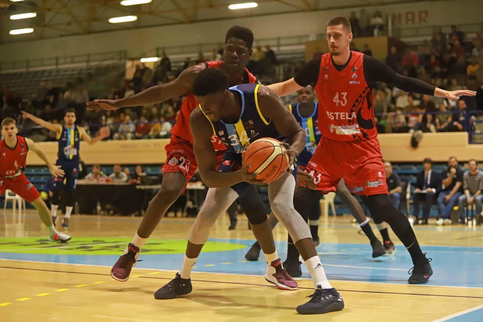 Mus Barro protege el balón ante dos jugadores del Estela.
