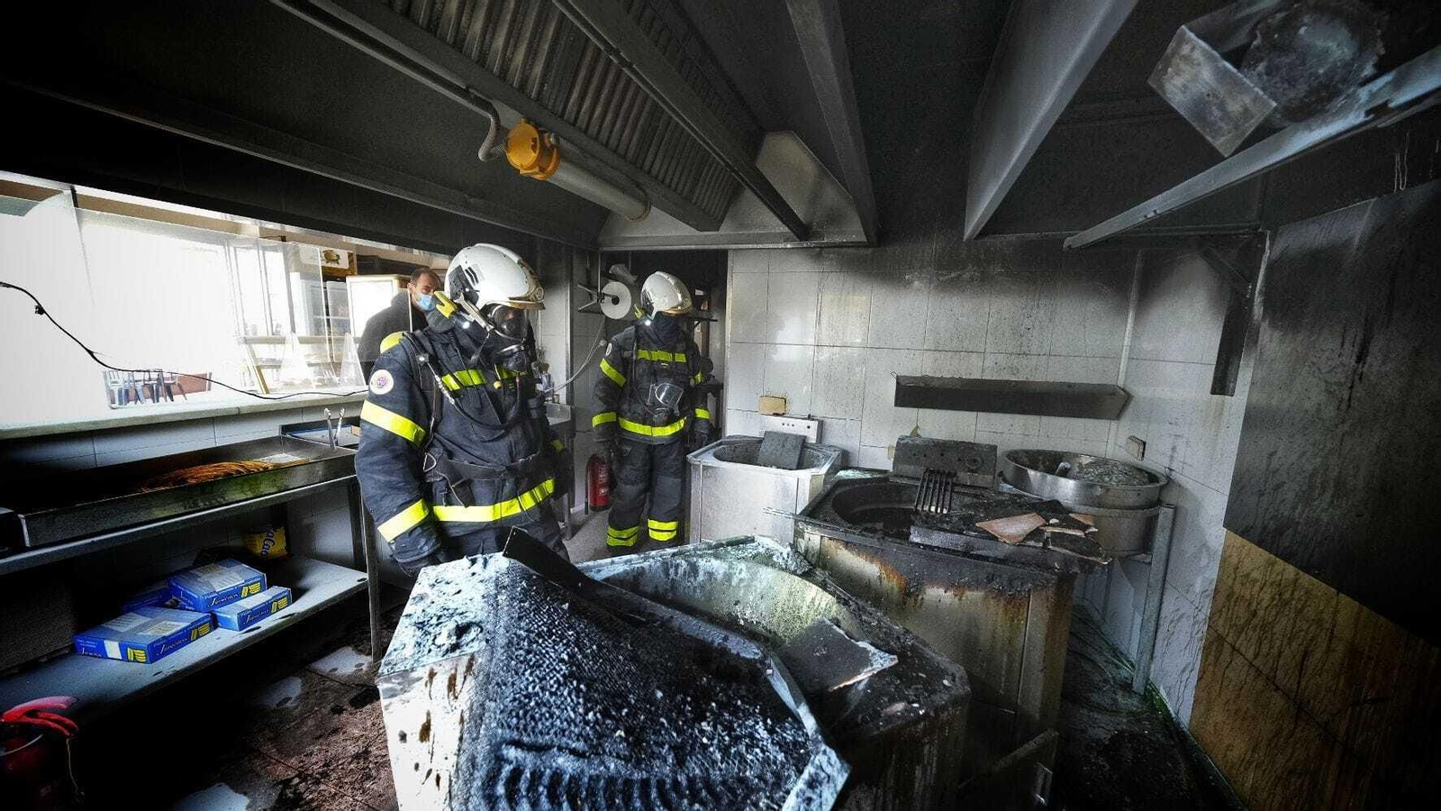 Los bomberos, dentro de la cocina del local.