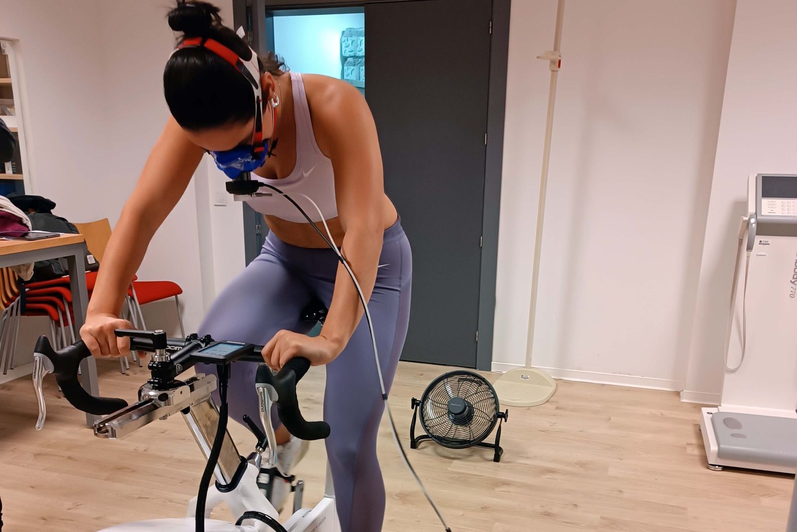 Una joven realiza esfuerzo físico sobre una bicicleta estática.