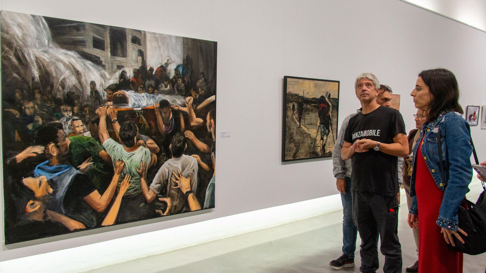 Varias personas vistando la exposición en la Nave del Azúcar de Motril