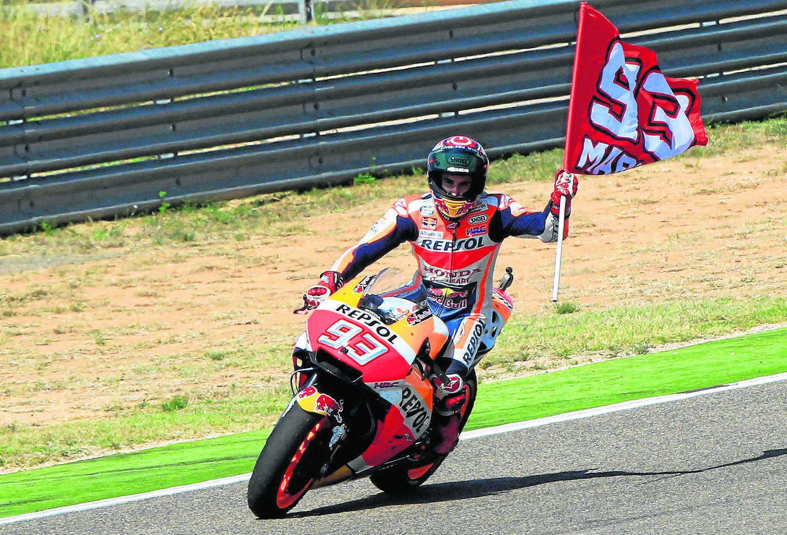 Marc Márquez enarbola una bandera con su dorsal para celebrar su triunfo en el trazado de Alcañiz.