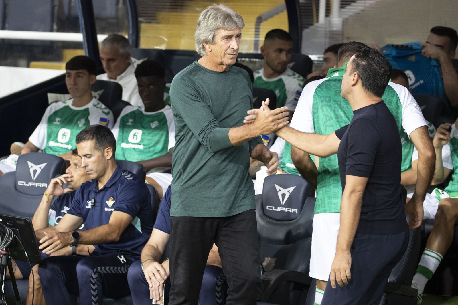 Manuel Pellegrini y Xavi Hernández se saludan antes del inicio del encuentro disputado en Montjuic el pasado sábado.
