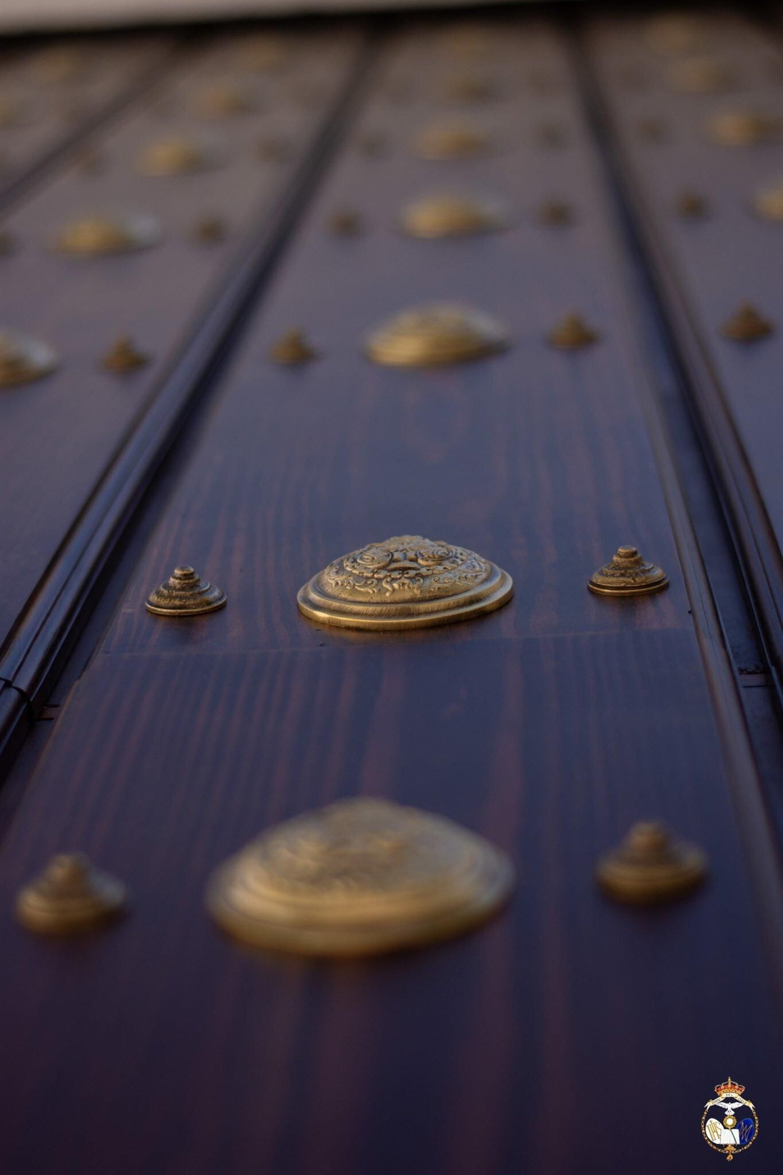 Primer plano de uno de los medallones de la puerta, con el escudo de la cofradía