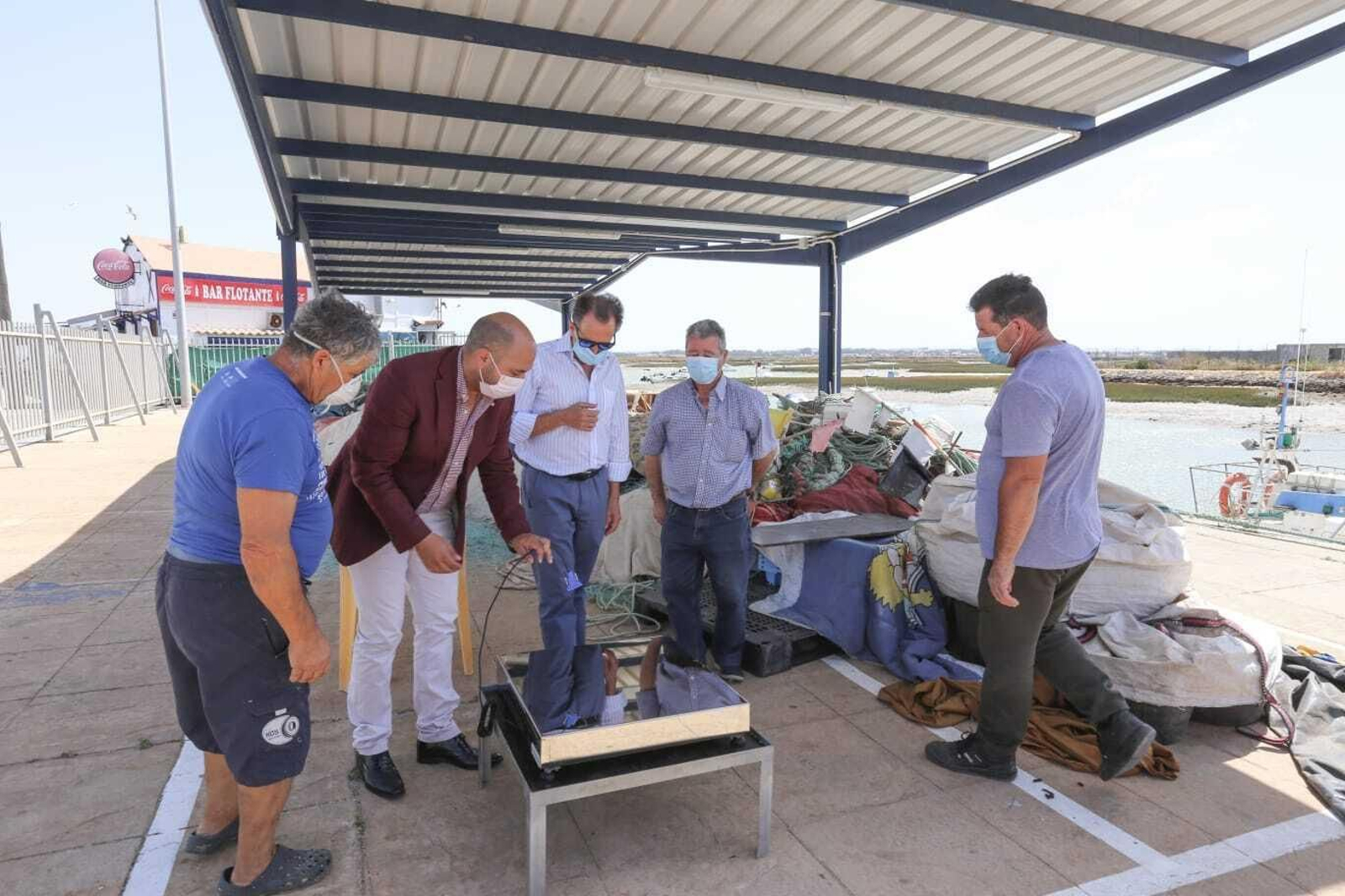 Representantes municipales y de la cofradía de pescadores frente a la nueva báscula. Representantes municipales y de la cofradía de pescadores frente a la nueva báscula.