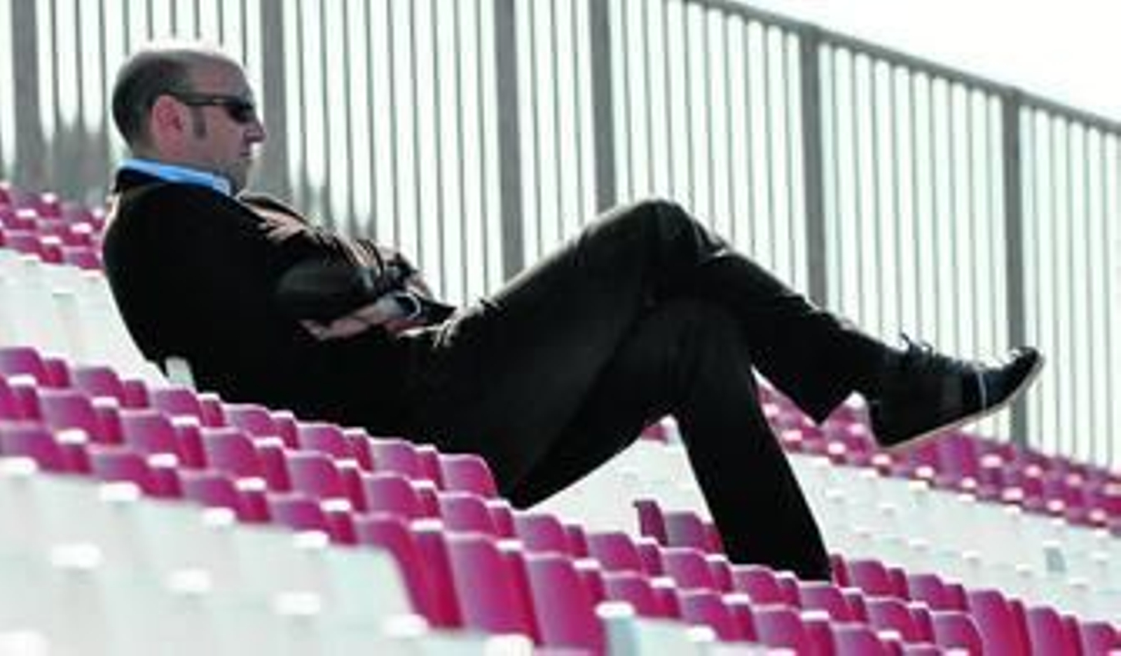 Monchi se acomoda en la grada de la ciudad deportiva mientras sigue un entrenamiento.