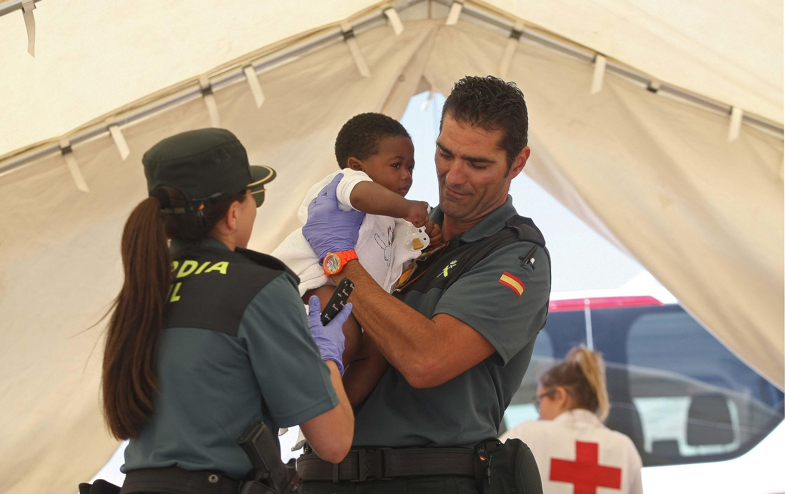 Dos agentes de la Guardia Civil atienden a un niño recién llegado a Tarifa.